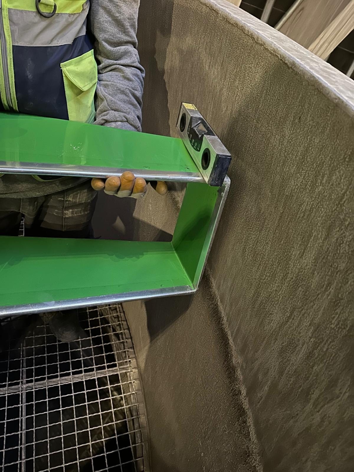 Technician checking a blade tip against the fan stack wall with a level
